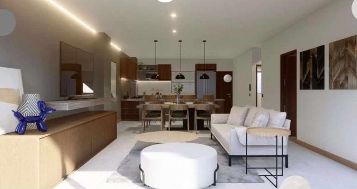 Sala y comedor integrados con sofá blanco, consola de madera y lámparas colgantes negras
