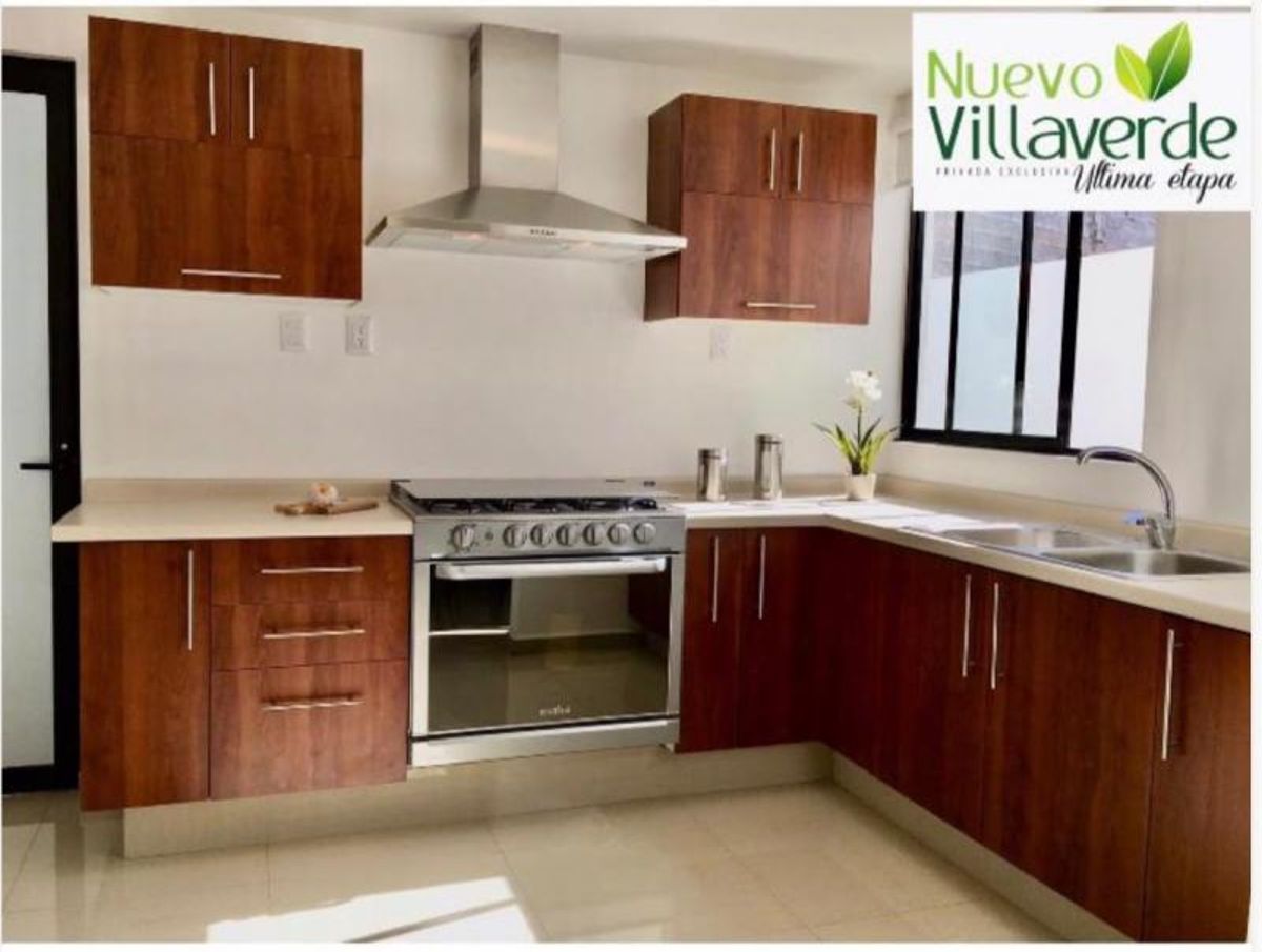 Cocina integral con gabinetes de madera, estufa de acero inoxidable y campana extractora