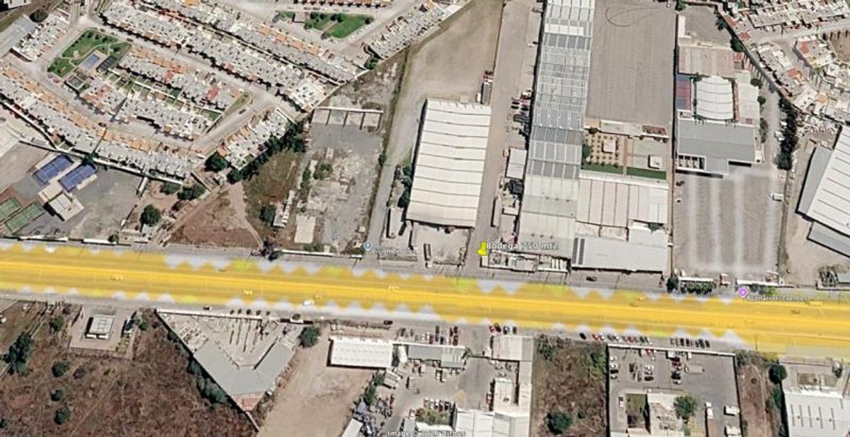 Vista aérea de un boulevard resaltado en amarillo junto a bodegas e instalaciones industriales
