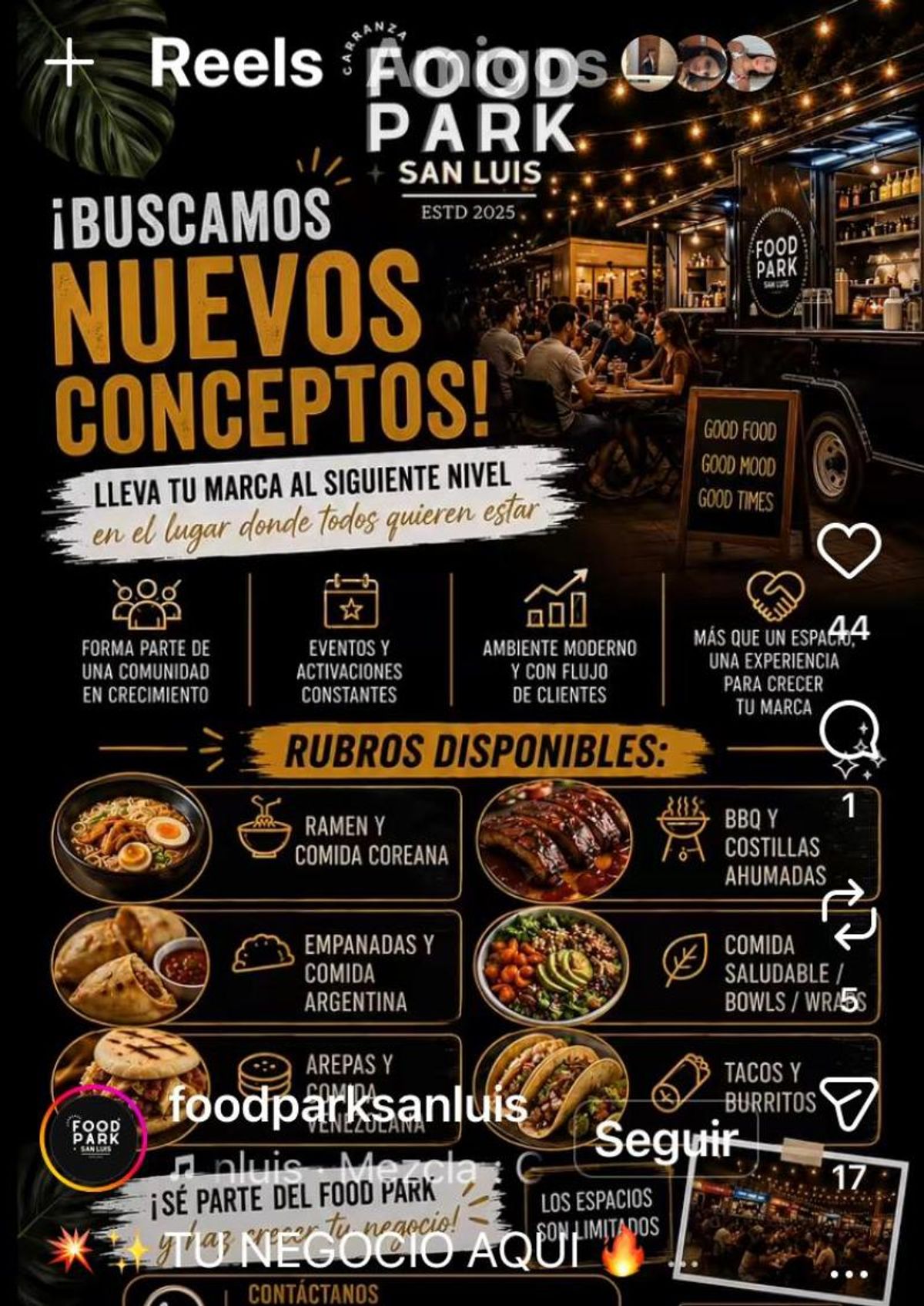 Espacio comercial al aire libre nocturno con mesas de madera, luces colgantes y locales