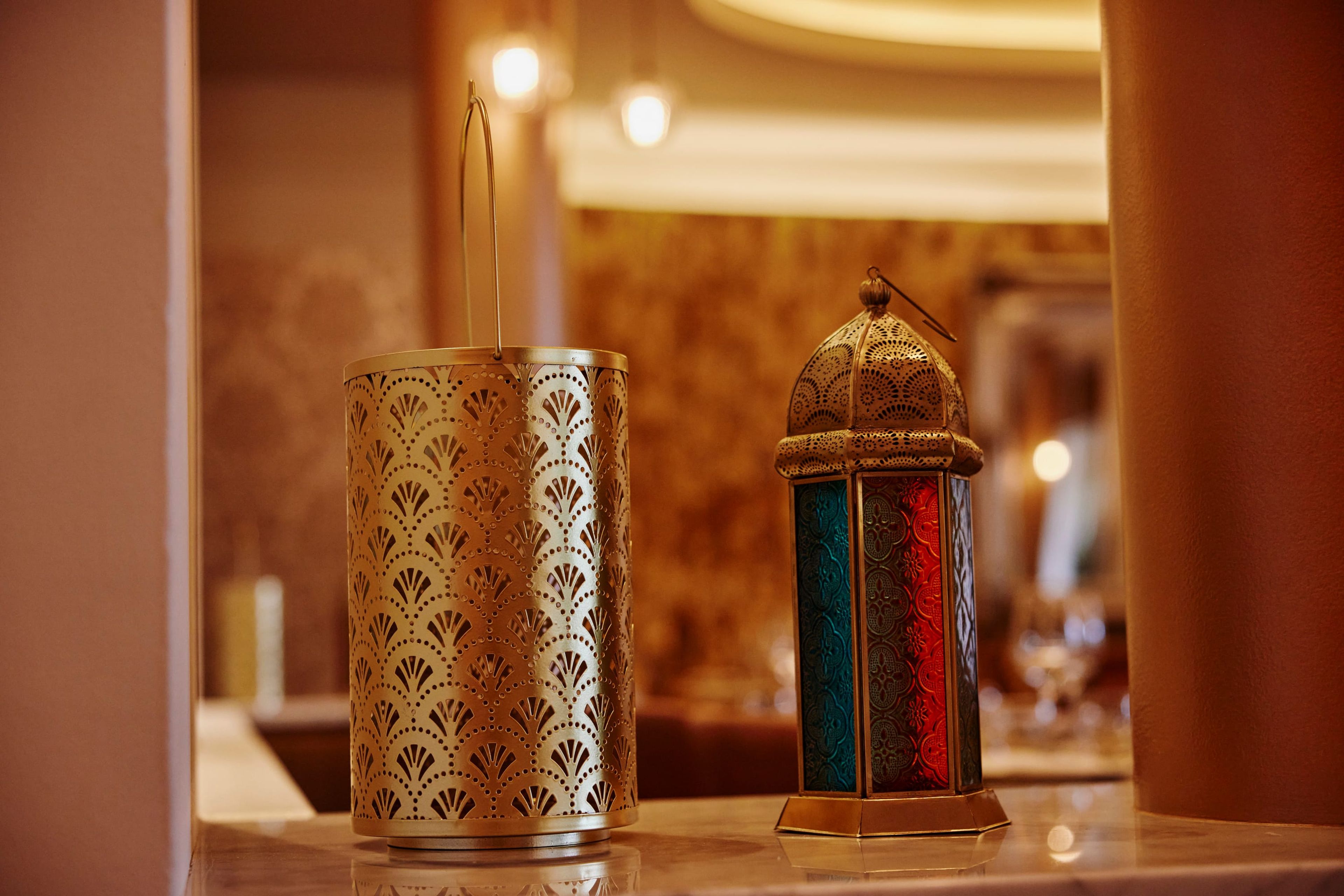Brass and coloured-glass lanterns glowing on a table in the SONA dining room