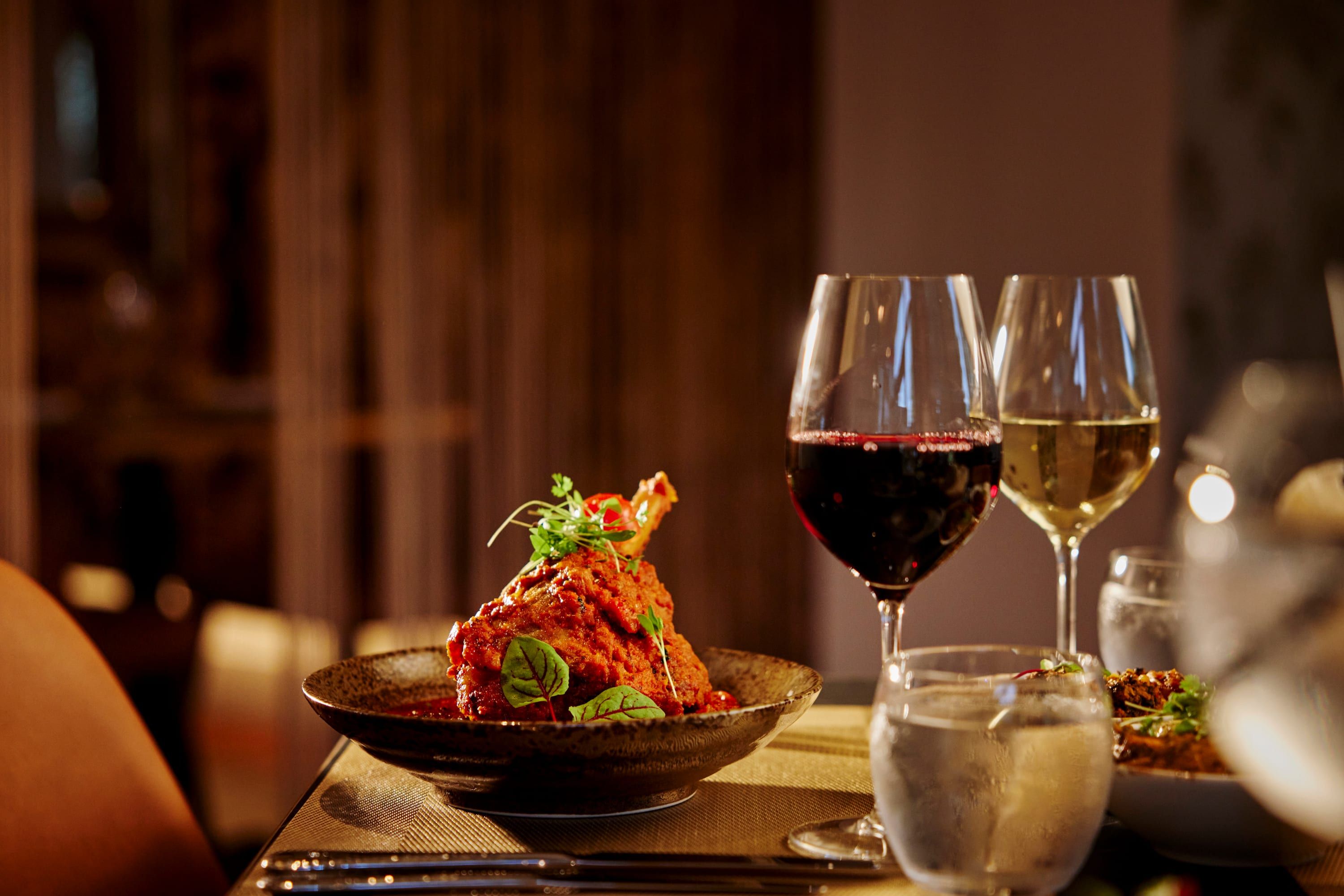 Slow-cooked lamb shank with herbs, served with red and white wine