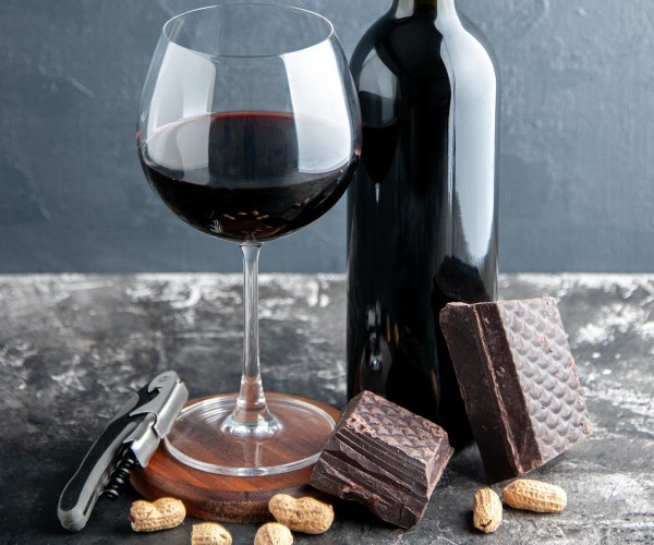Glass of Red Wine with bottle and peanuts