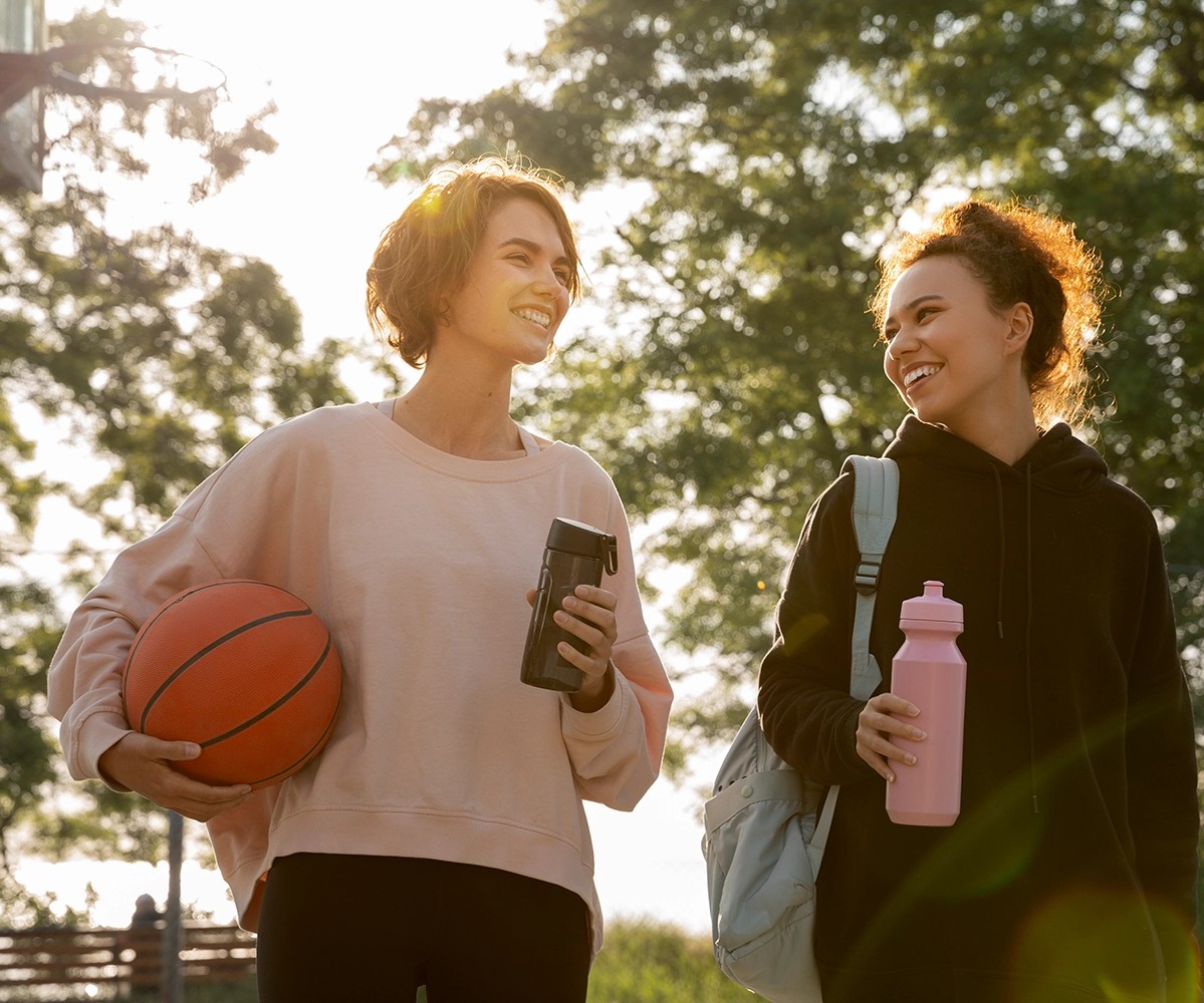 Women walking with basketball outside in golden hour