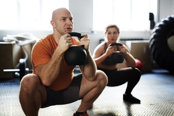 Try lifting with a kettlebell and performing Goblet squats; that is a good place to start before heading to the rack.