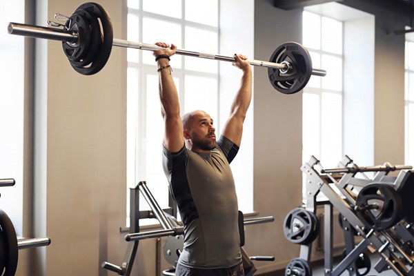 Lifting barbell above head at the gym