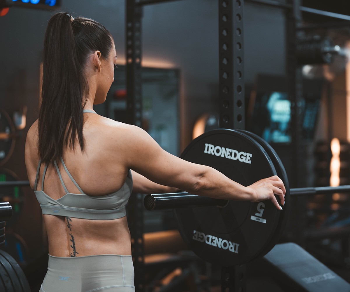 Helena Sly loading a bar in the gym