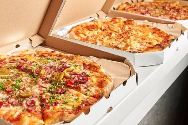 Three delicious looking pizzas ready to be eaten by starving bodybuilders after the show.
