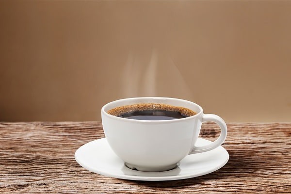 A steaming hot long black in a white cup.