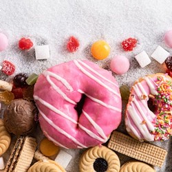 A bounty of sweet, sugar-filled confectioneries like donuts, biscuits, lollies, and chocolates.