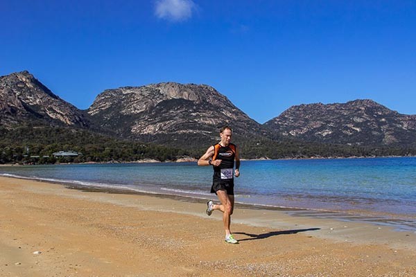 Sponsored Bulk Athlete Chris Sullivan running the Freycinet beach in Tasmania.