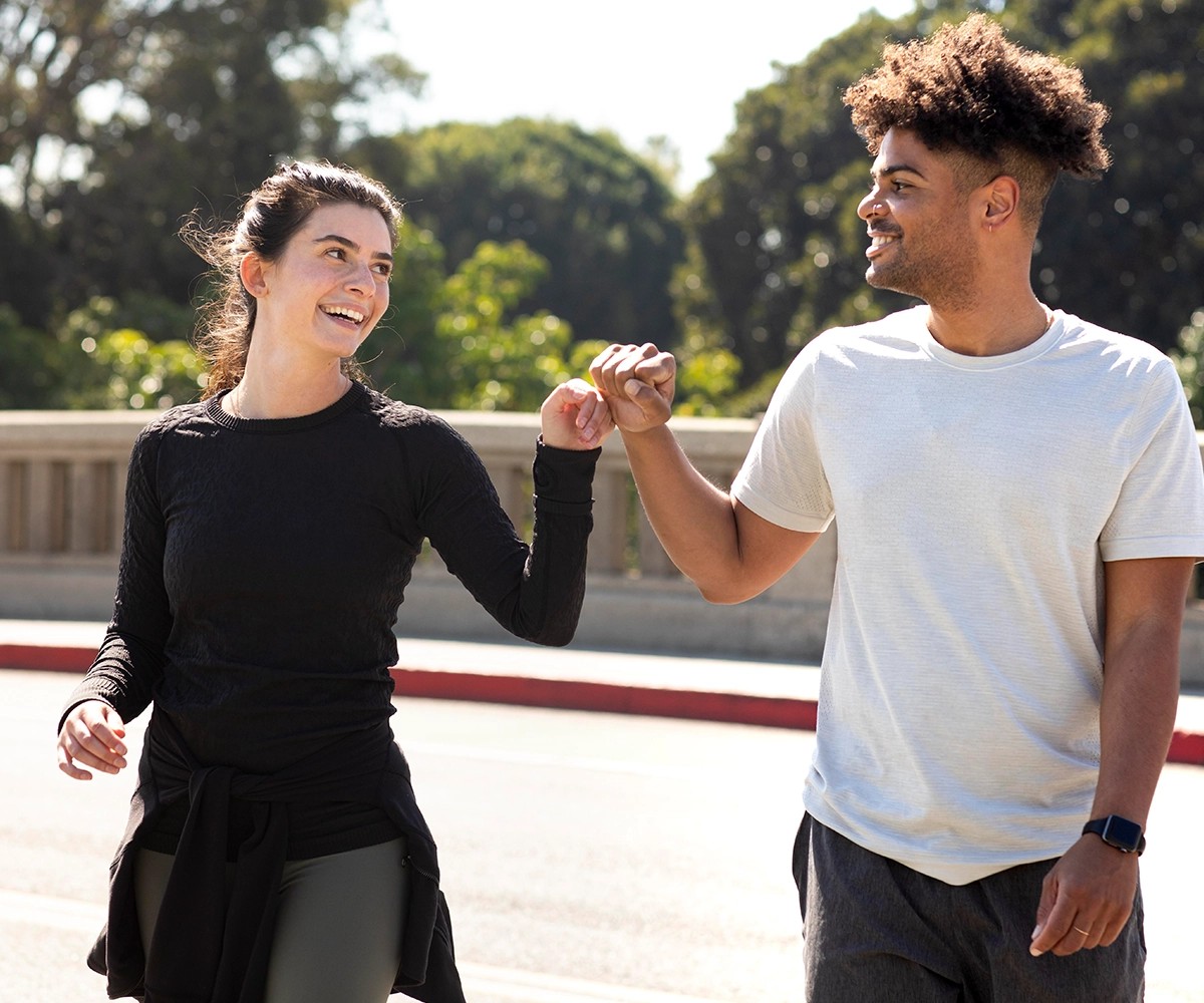 Young friends jogging doing fist bump
