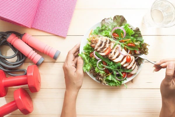 A person eating a healthy chicken salad.
