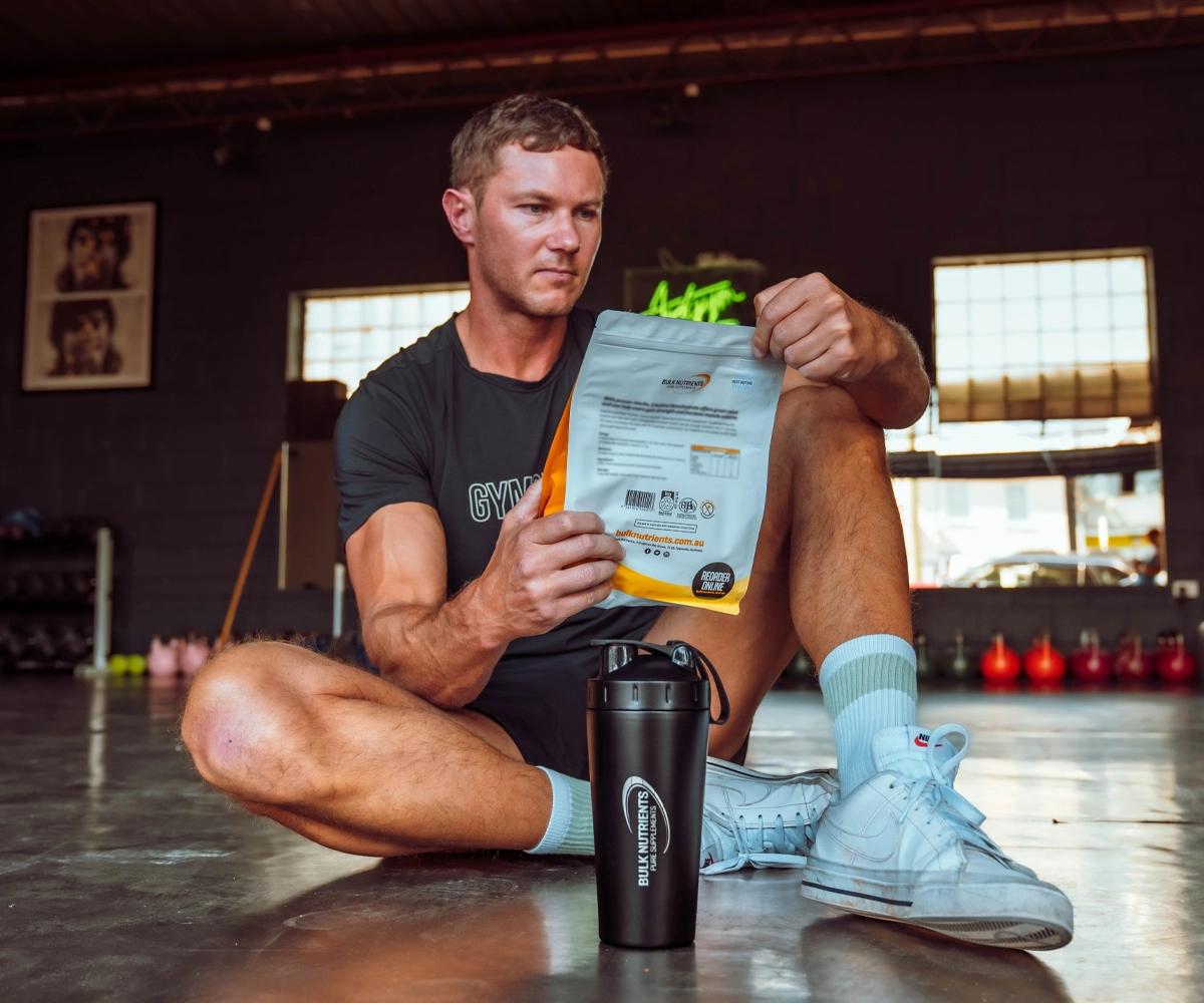 Ryan Van Duiven looking at a Bulk Nutrients Bag with Black Stainless Steel Shaker