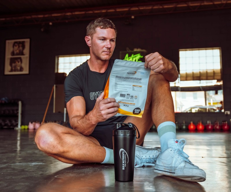 Ryan Van Duiven looking at a Bulk Nutrients Bag with Black Stainless Steel Shaker
