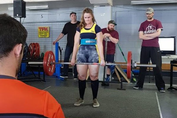 Ellie performing a dead lift in Competition