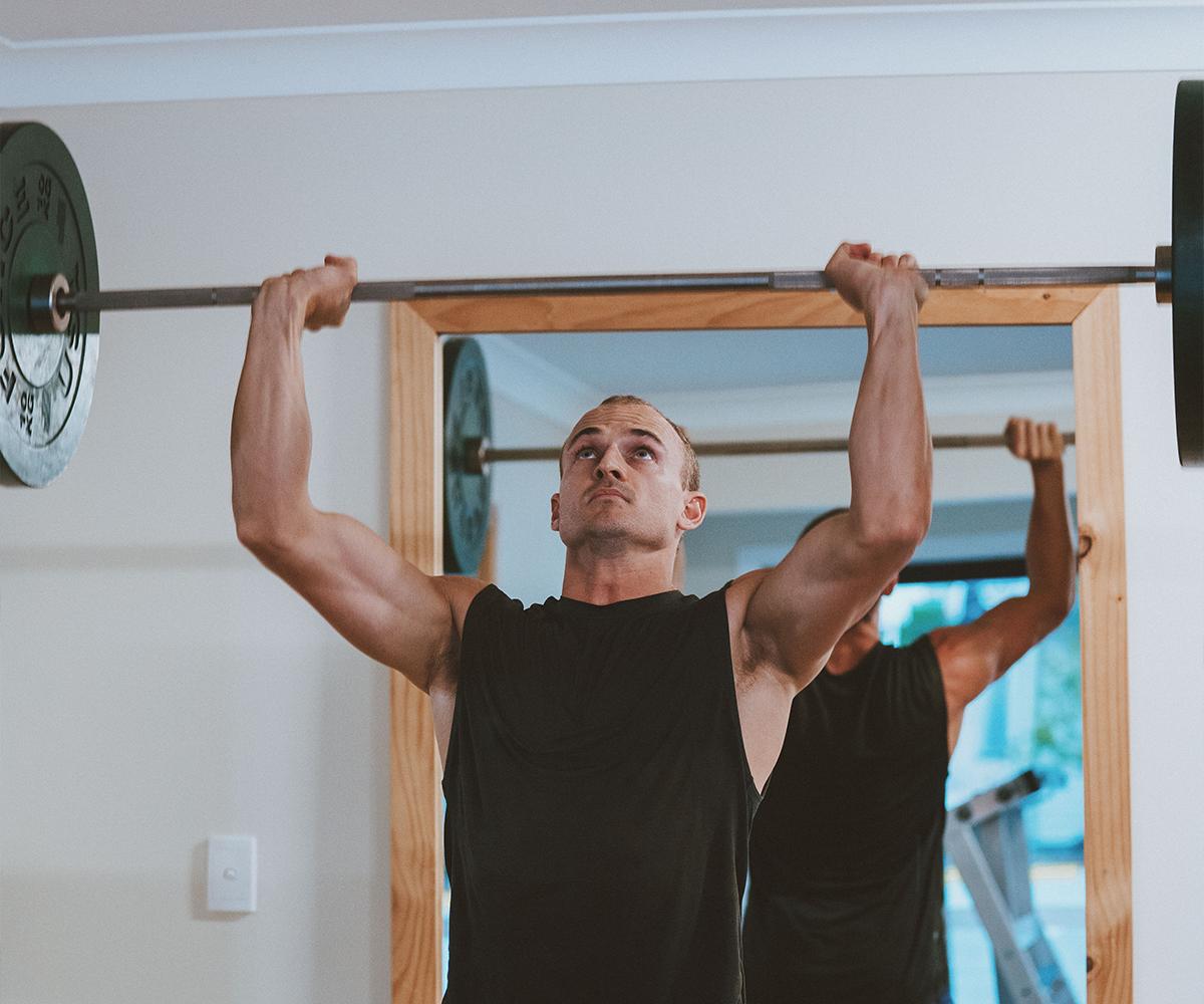 Lifting barbell above head at the gym