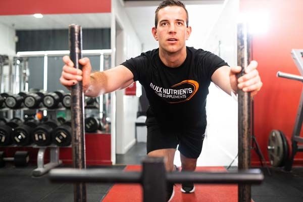 Bulk Ambassador Ben Disseldorp performing a sled push in the gym. 