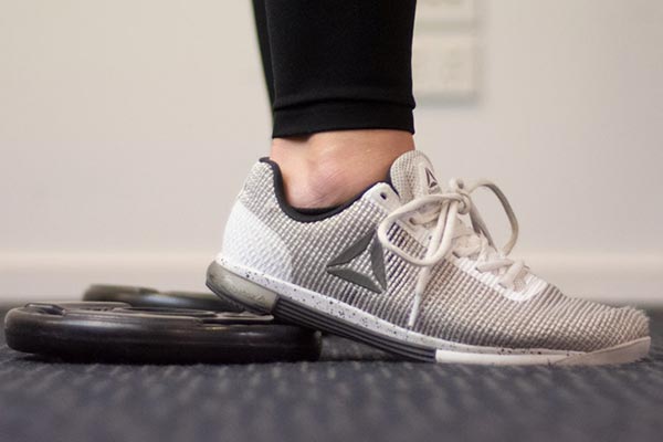 Standing on a plate can help improve your ankle mobility while front squatting