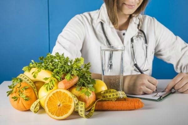 A woman studying the fibre content of a bunch of fruits and vegetables.