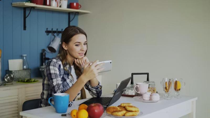 woman-video-calling-on-phone-at-kitchen-tabl