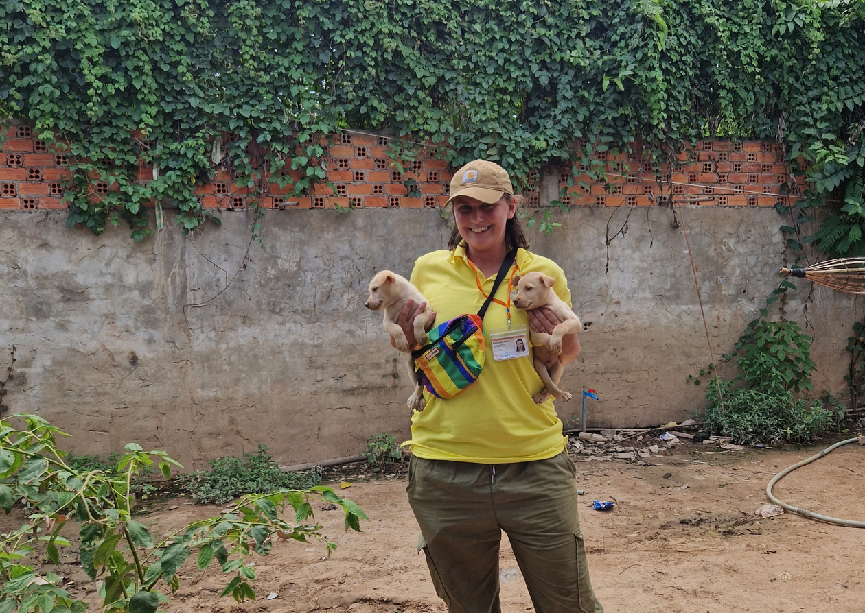 A women holding two puppies.