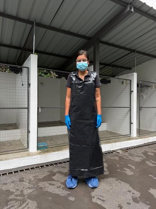 Person wearing PPE including bin bag apron