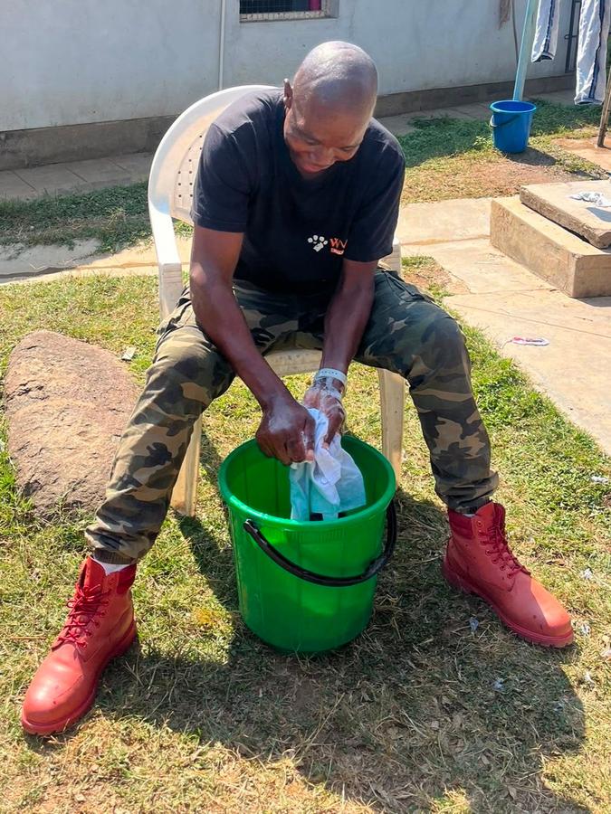 WVS staff member washes laundry by hand