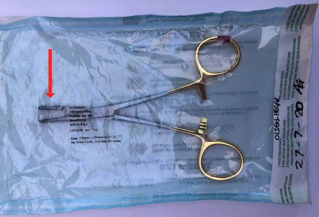 Figure 3 - Olsen-Hegar needle holders are in their 'open' position (arrow) in order to ensure complete sterilisation of all surfaces.