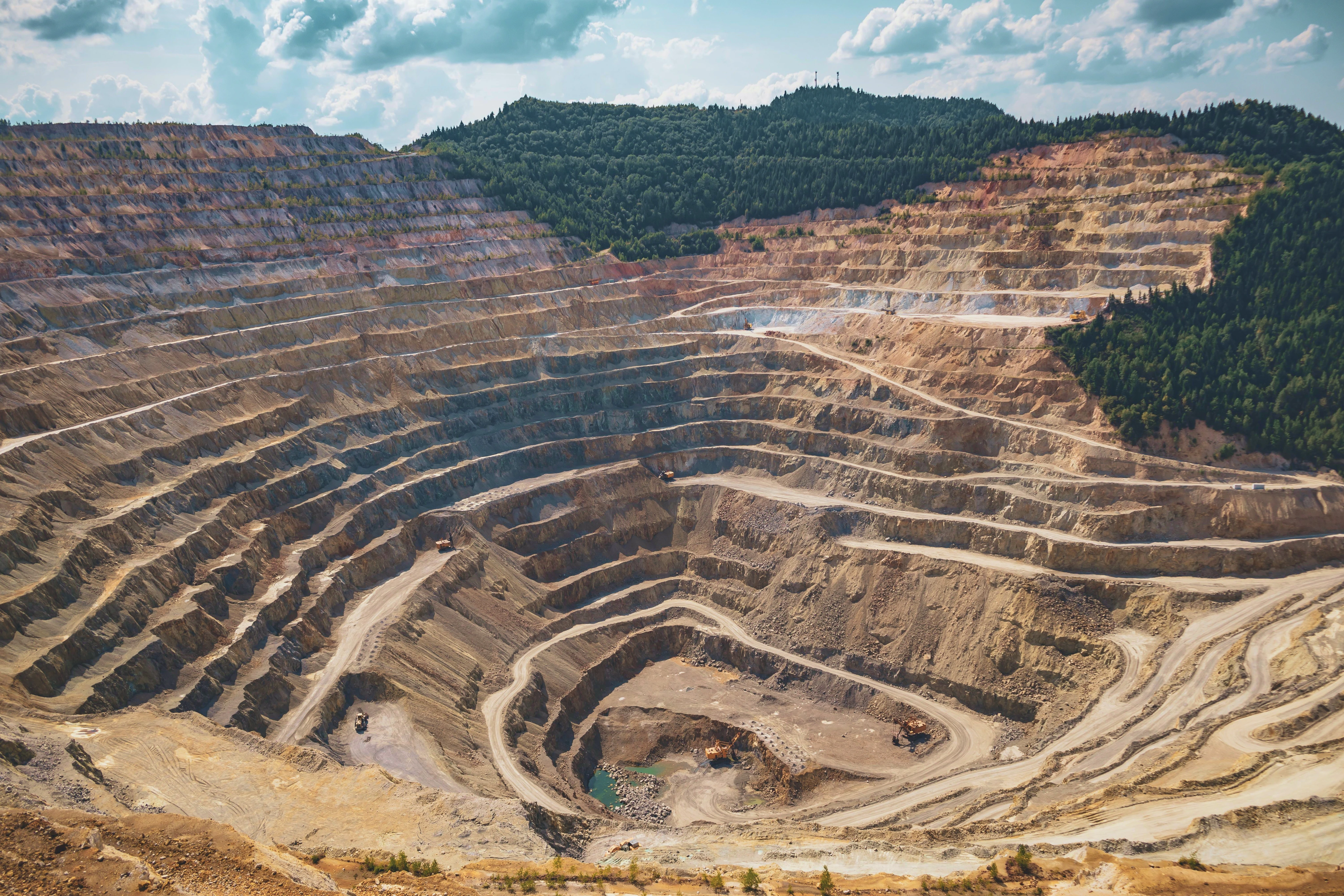 Open-pit mine surrounded by forested hills