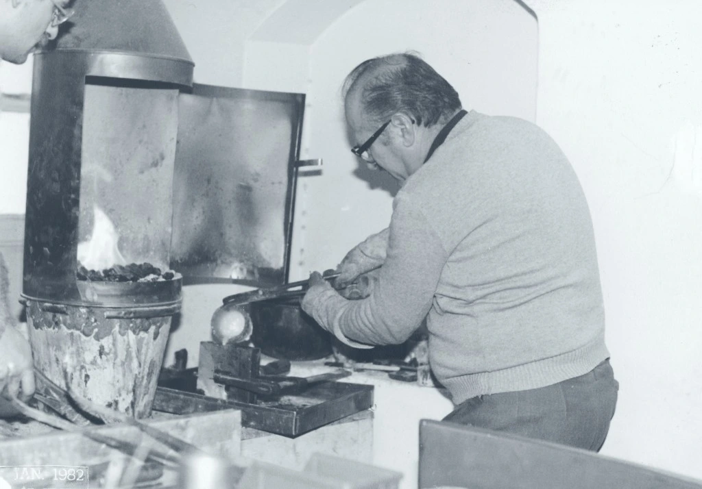 Jeweler heating and pouring metal at the workshop furnace, January 1982