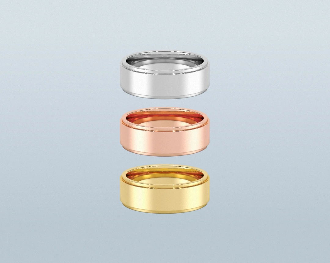 White, rose, and yellow precious-metal wedding bands arranged vertically