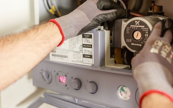 Heizungsmonteur wartet eine Heiztherme – SEO für Handwerker macht SHK-Betriebe online sichtbar