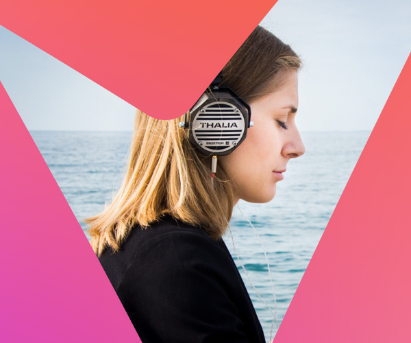 Mujer relajada escuchando música con sus auriculares frente al mar