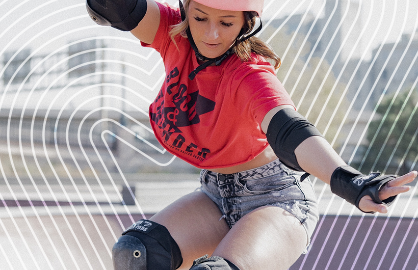 woman in pink helmet, crop top and shorts, skateboarding