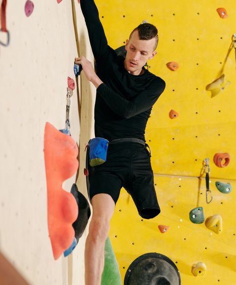 A man with a physical disability, working his way along a climbing wall 