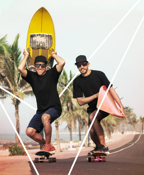 Two men holding surfboards while skating 