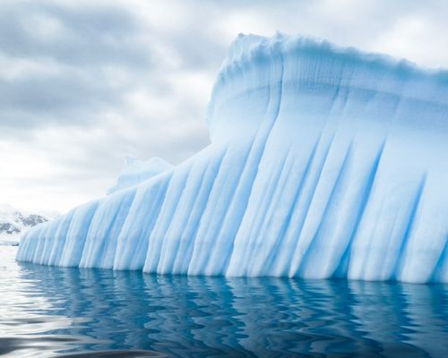 a lateral de um iceberg gigante em água azul brilhante