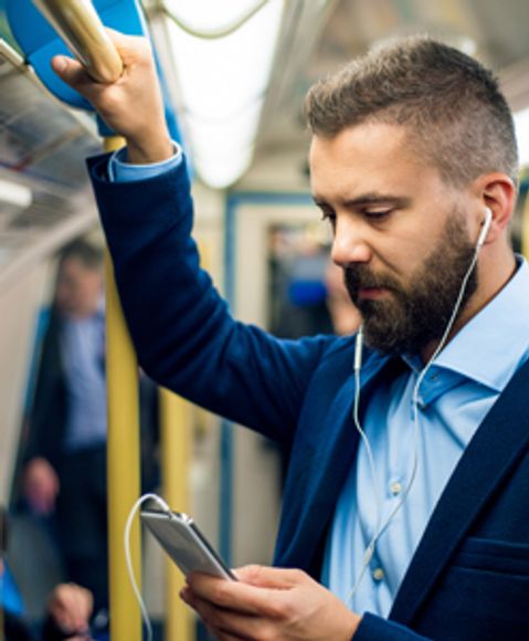 Man looking at his phone during his daily commute. 