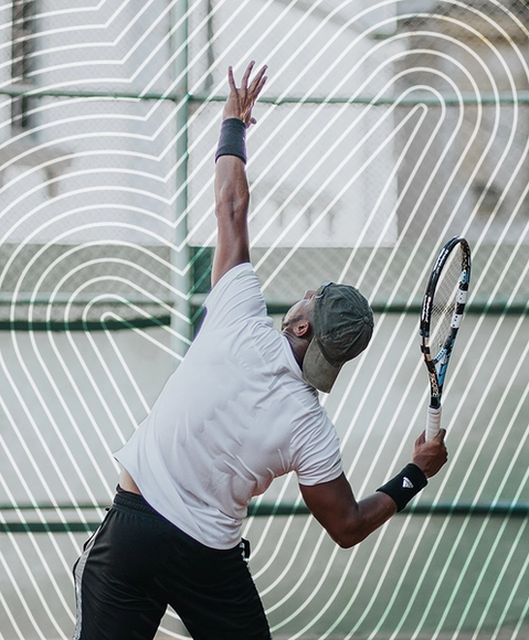 Un homme avec le dos en sueur pendant un service de tennis 