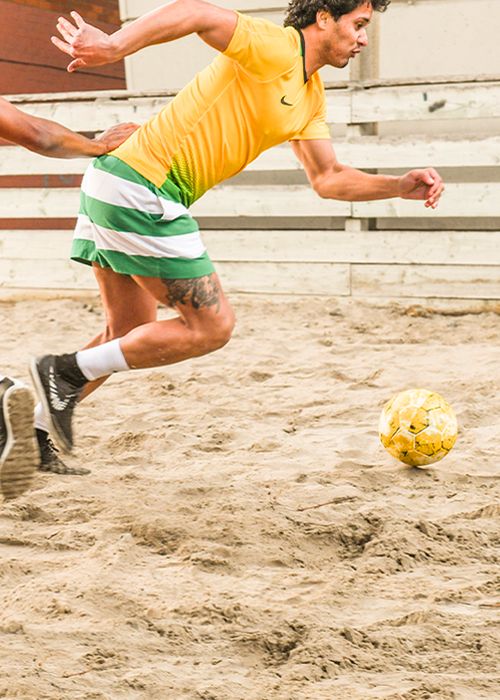 Men playing beach soccer 