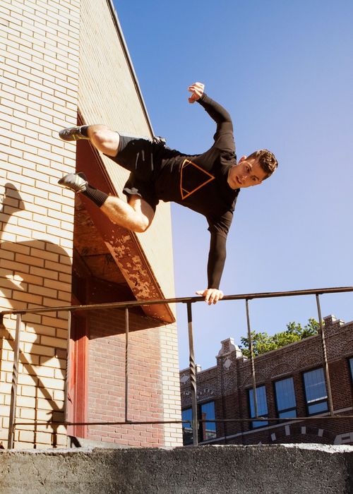 Man jumps over stairs performing parkour in an urban environment