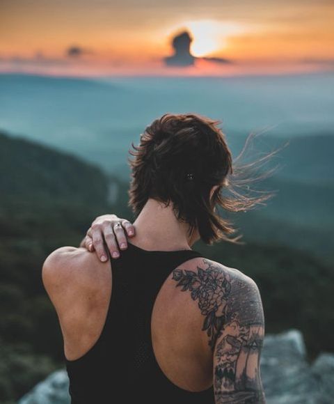 mujer con una mano detrás de la espalda admirando el paisaje