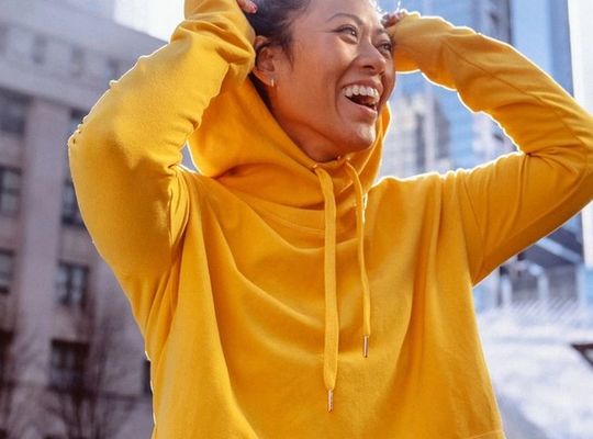 femme heureuse en sweat à capuche jaune, la science de la sueur 