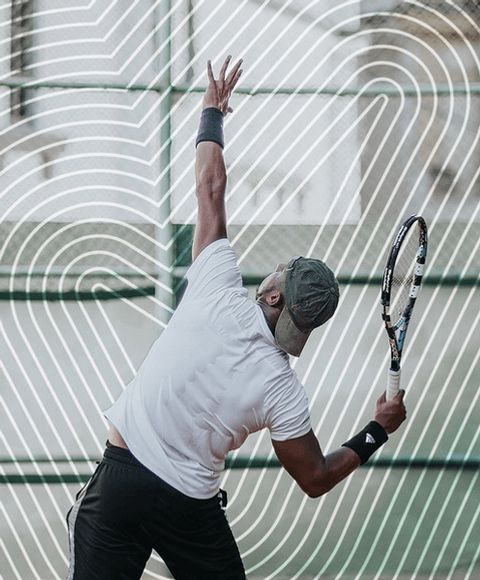 Ein Mann mit verschwitztem Rücken während eines Tennisaufschlags