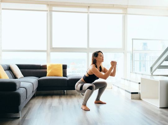 woman stretches during a workout in her apartment. 