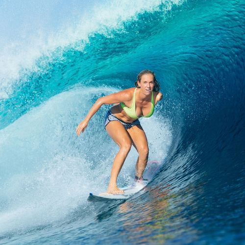 Bethany surfing on a crest of a blue wave