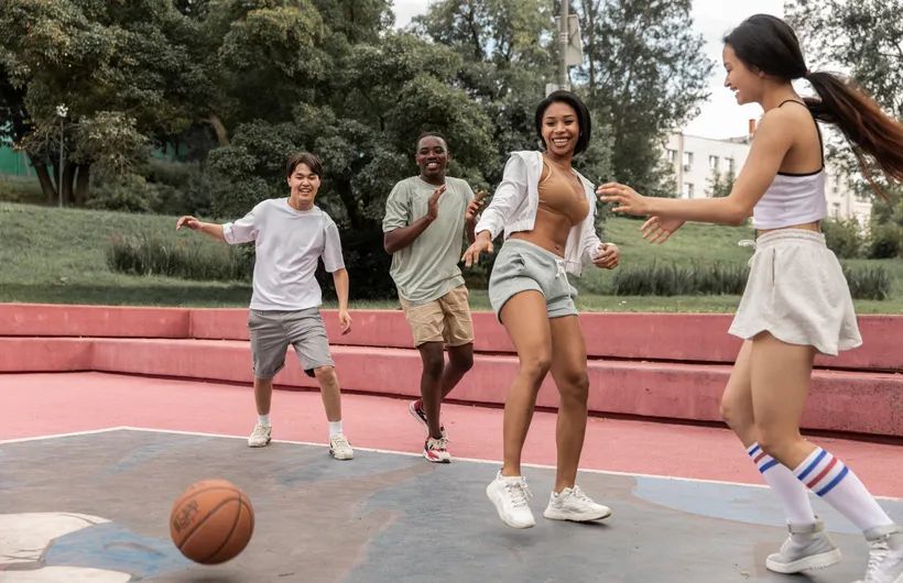 Diverse mixed group of teenagers playing basketball