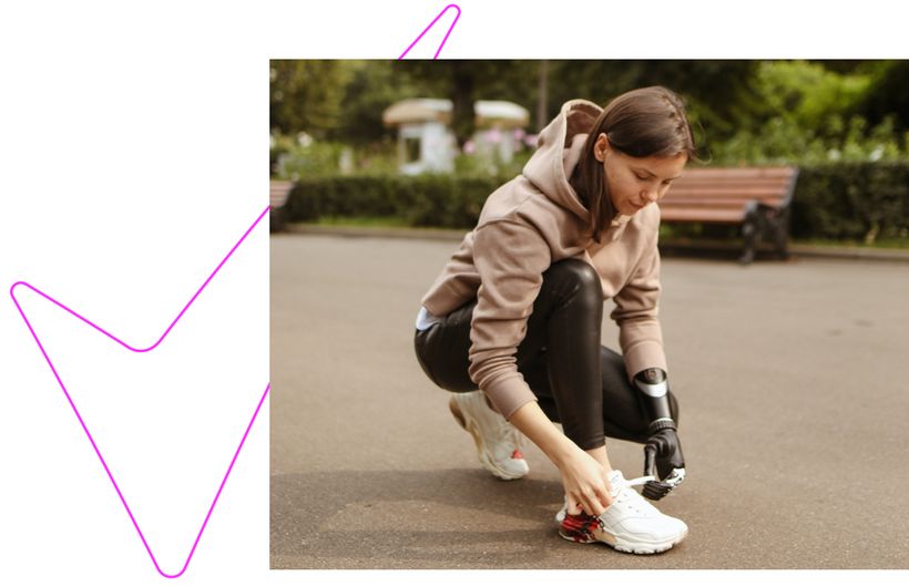 woman on run tying shoe with prosthetic hand