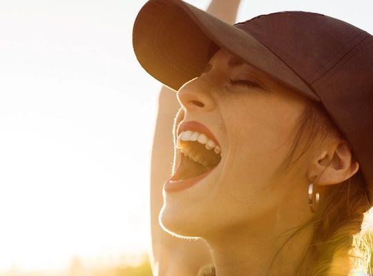 Woman happy and smiling with the sun on her face. 
